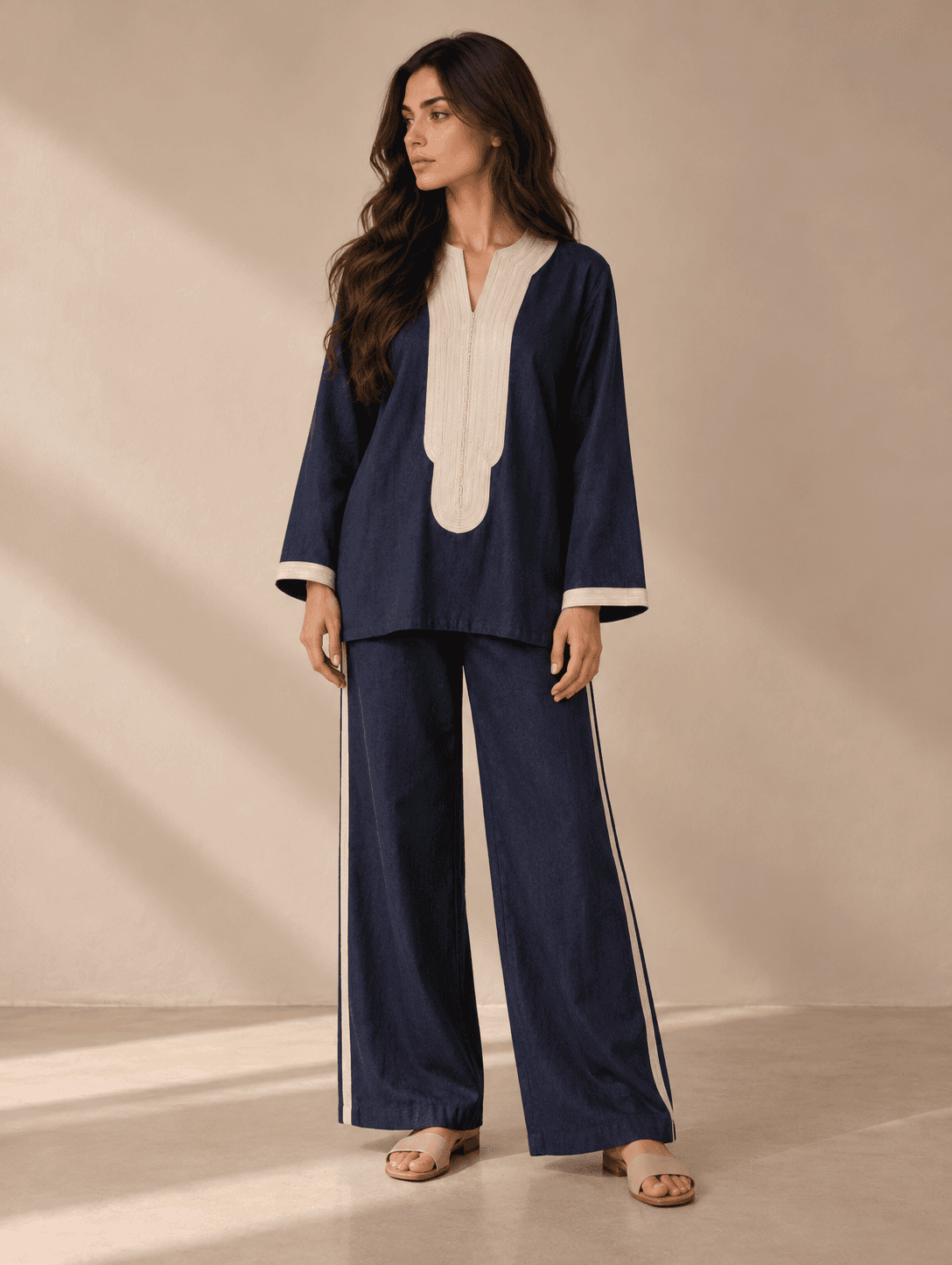 Solstice — A deep midnight-blue ensemble with a textured ivory panel at the neckline and matching cuffs.